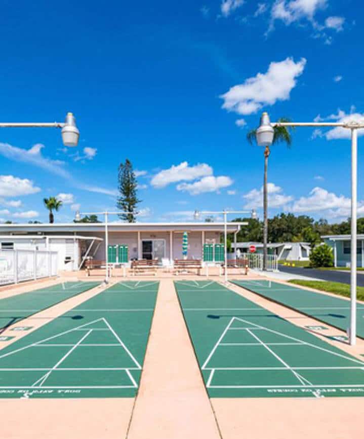 Outdoor shuffleboard courts with pole lamps