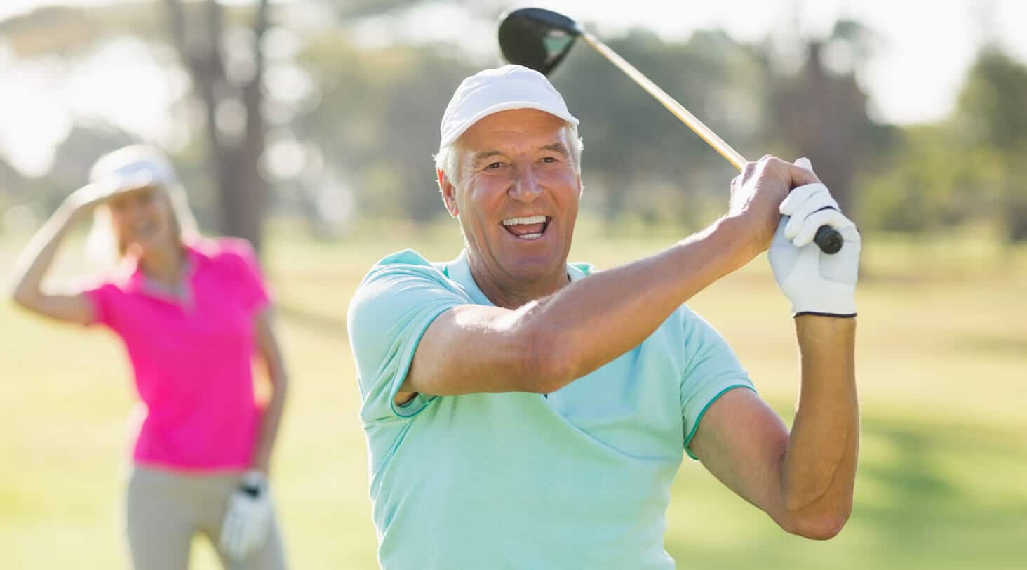 A gentleman smiles after swinging a golf club in the course in Sarasota, Florida.